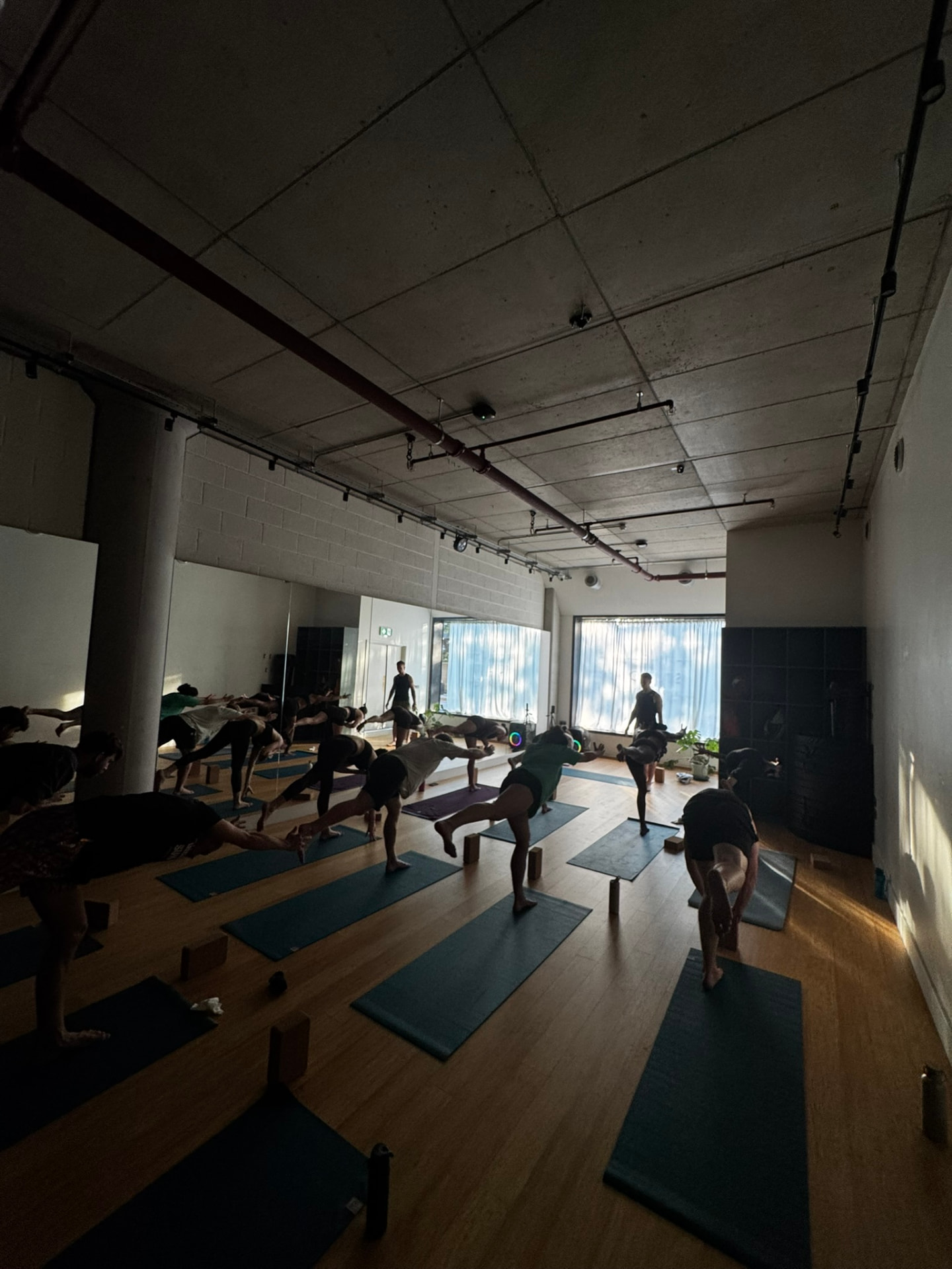 Balancing poses across the studio floor in a W12 yoga class