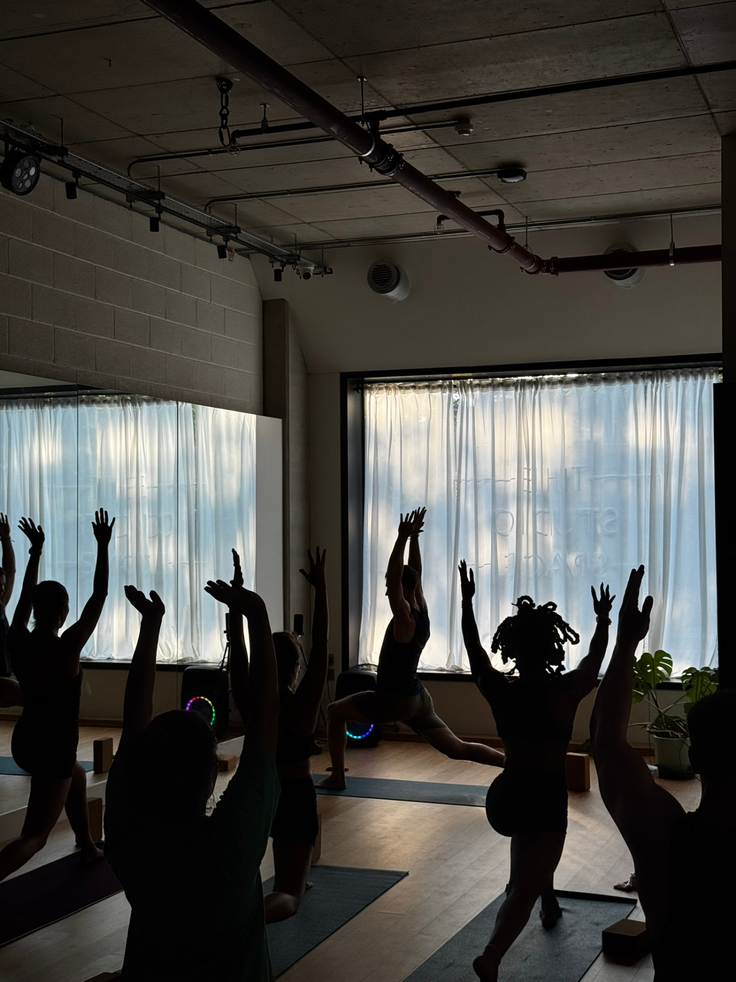 Class reaching into a crescent lunge at The Studio Space, White City